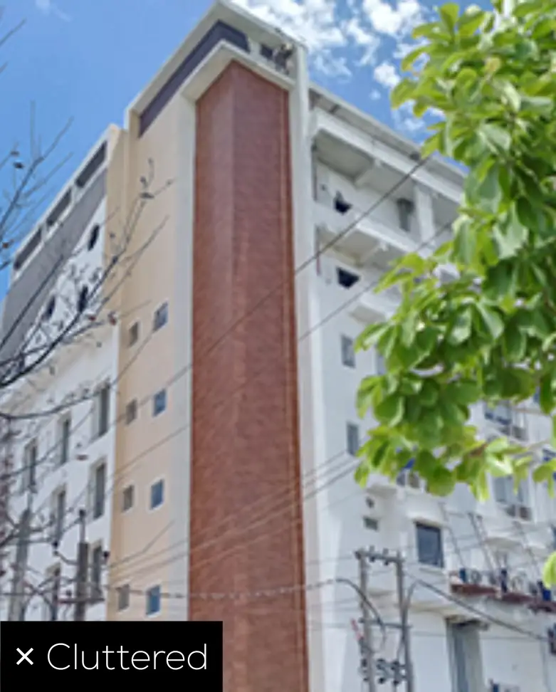 Cluttered building facade photo with trees and wires not suitable for Samrat HPL Design Lab upload