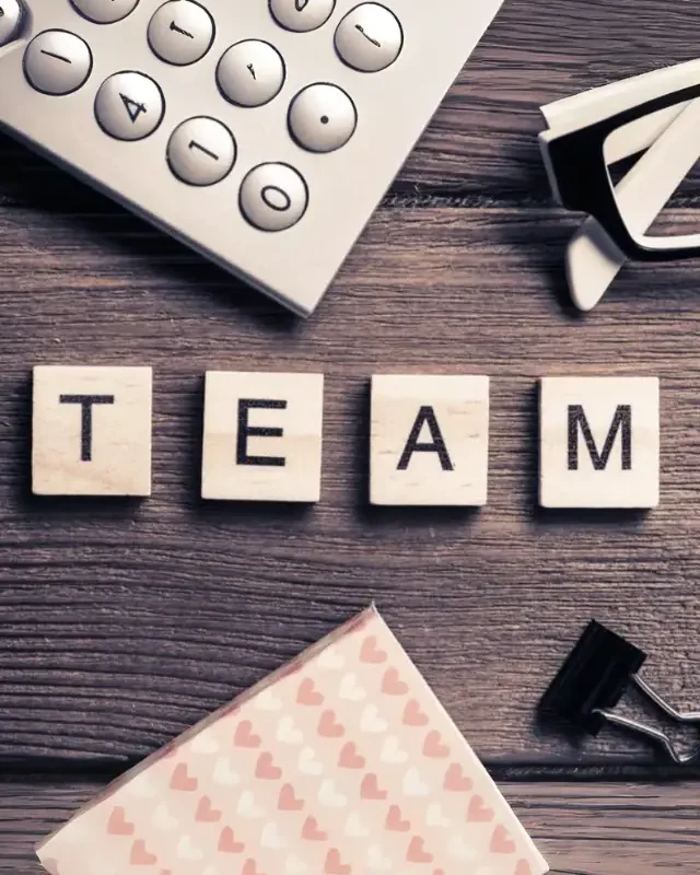 Wooden letter blocks spelling TEAM on an office desk